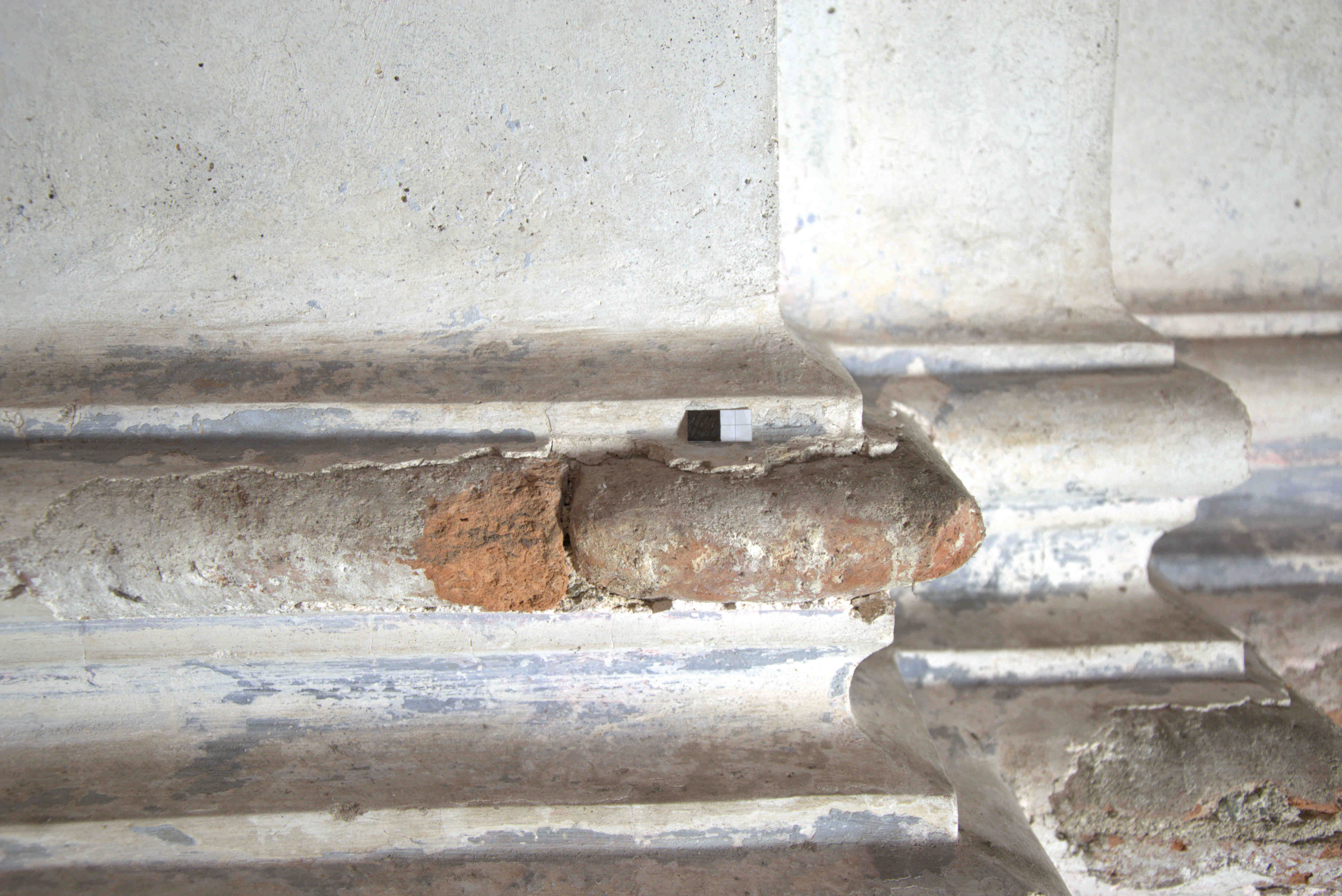 Detail of the base of a pillar made with rounded bricks.