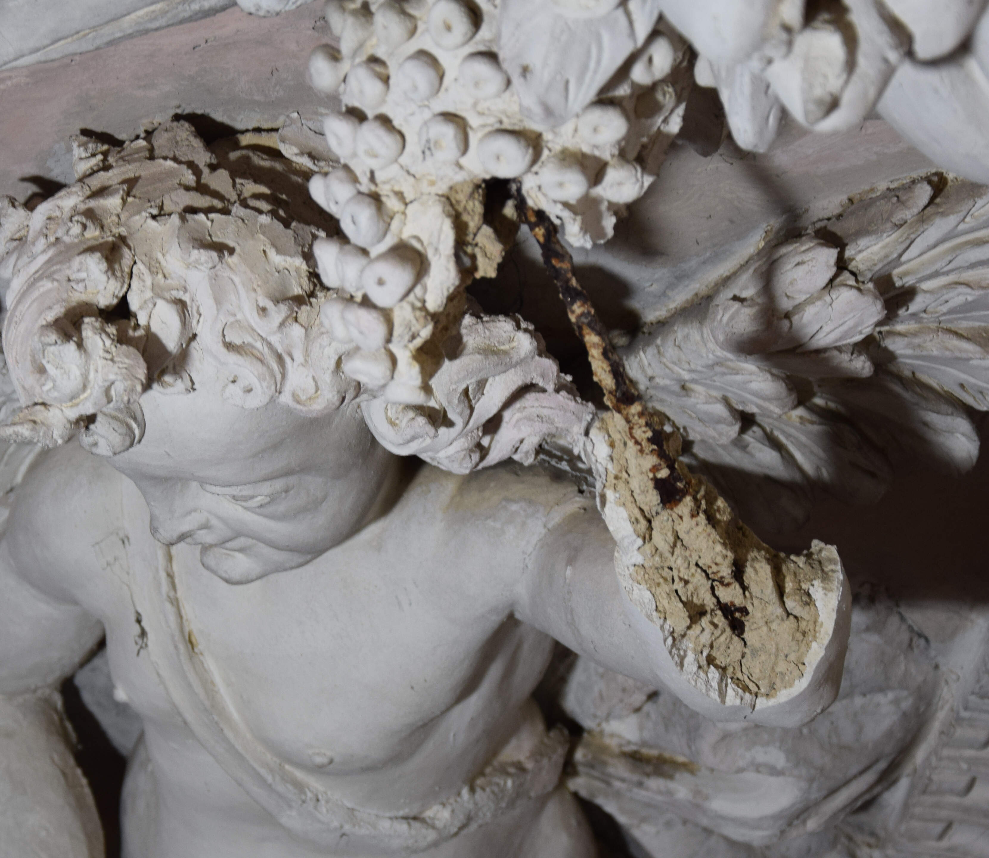 Detail of a deteriorated stucco decoration. The missing finishing layer exposes a coarse layer containing an ocher clay aggregate.