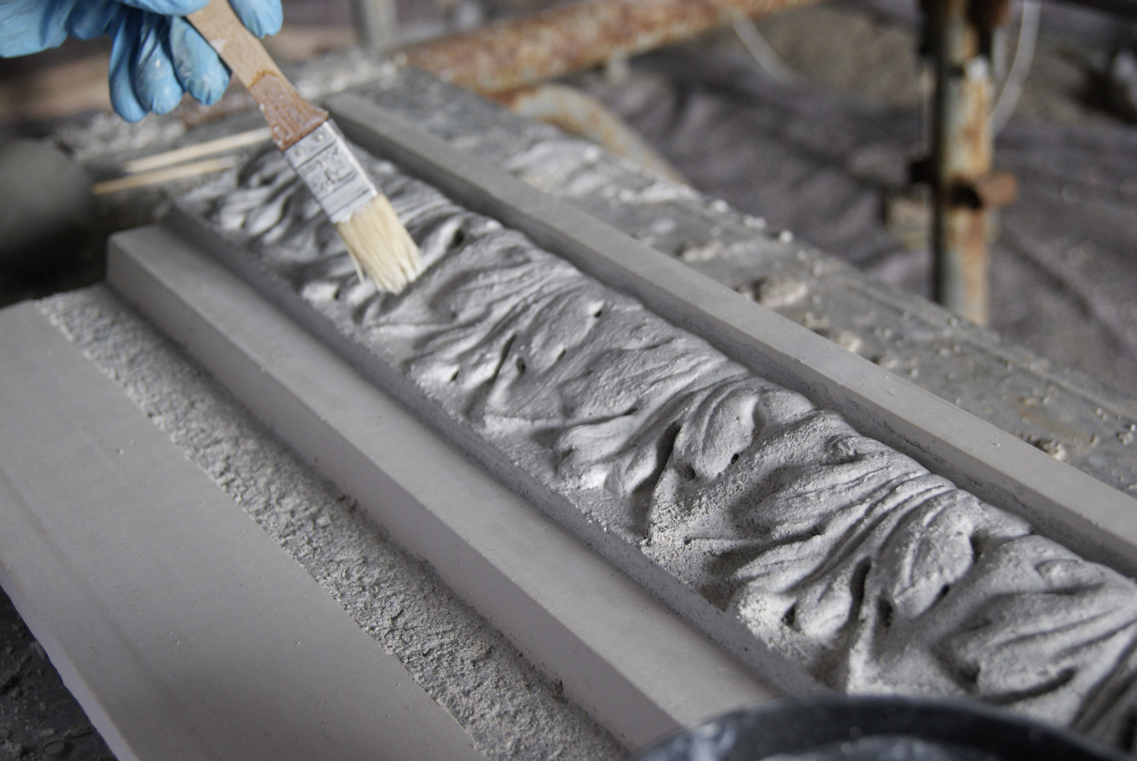 Stages of creating a decorated corniche using a press mould.