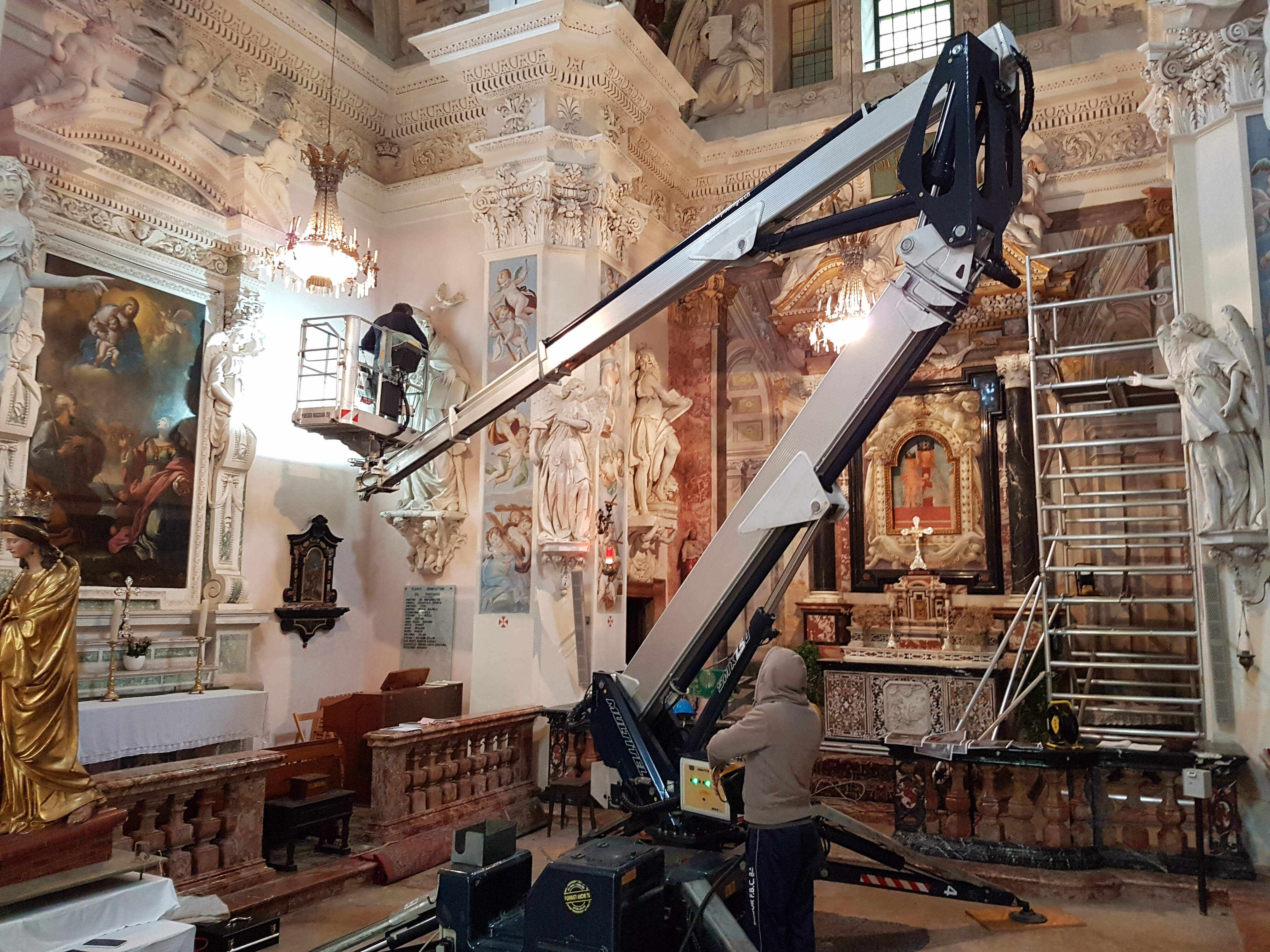  Members of the research team conduct a close-up inspection of a stucco decoration using a movable platform.