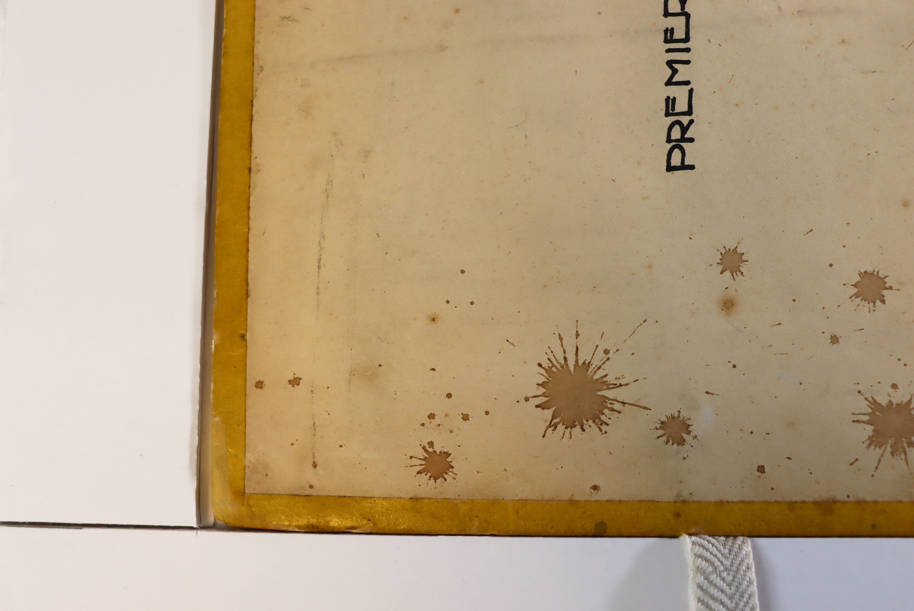 Close-up of the lower left corner of the first floor-plan of the Maison d'Artiste, showing stains, spots and the yellow glazed paper frame.