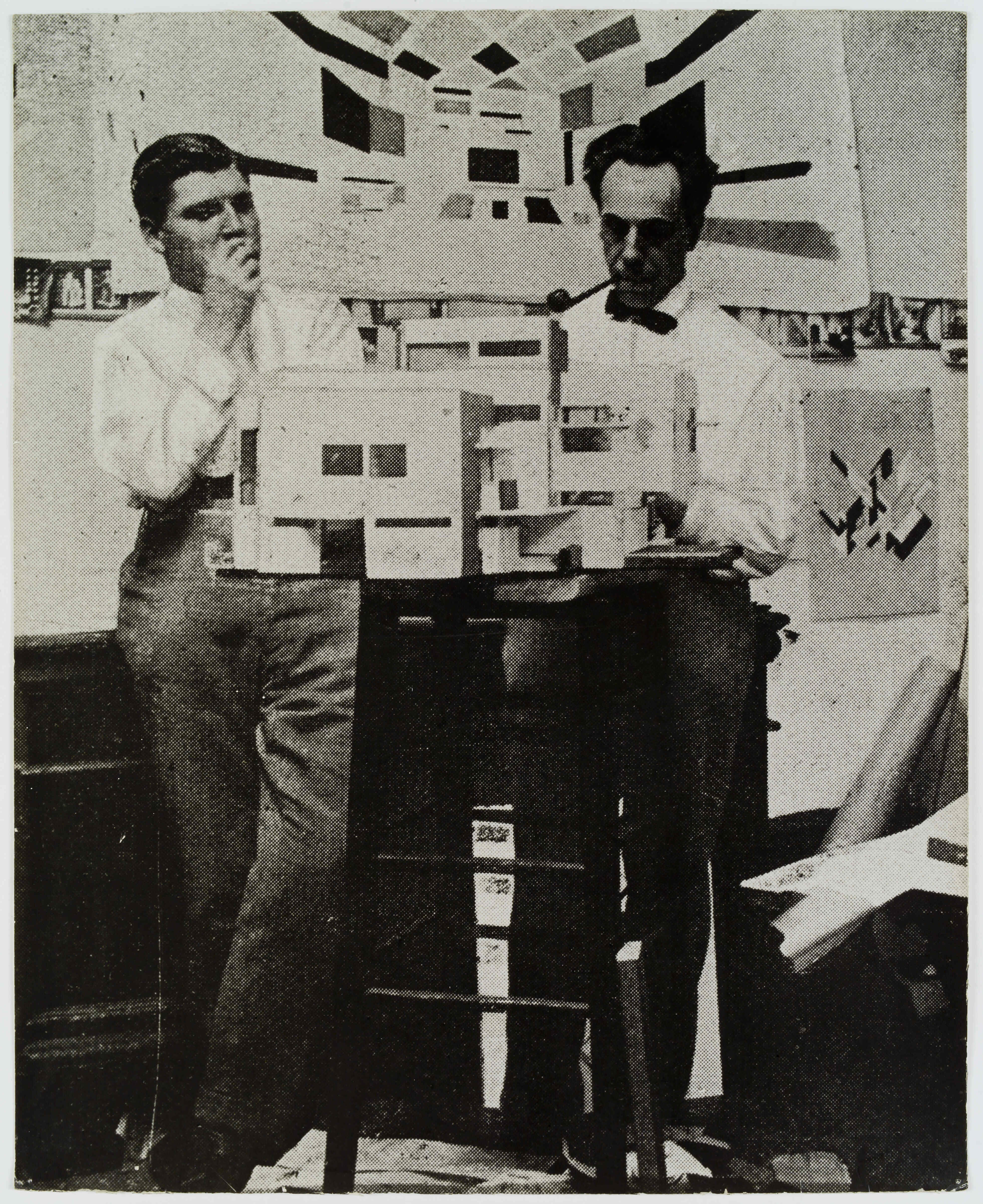  Black and white photograph of Cornelis van Eesteren (left) and Theo van Doesburg (right) posing behind a maquette of Maison Particulière in their studio.